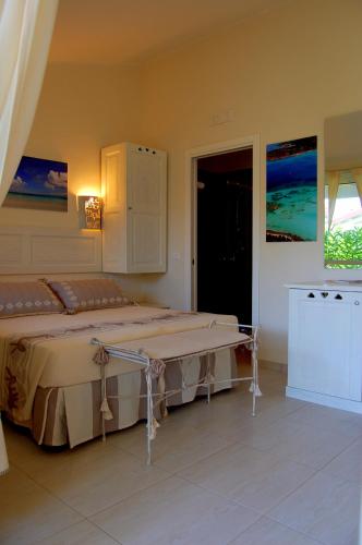 a bedroom with a large bed and a table at Hotel Budoni Beach in Budoni
