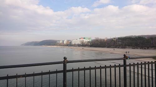 a view of the beach from a fence at Apartament Orchidea New Slavia in Międzyzdroje
