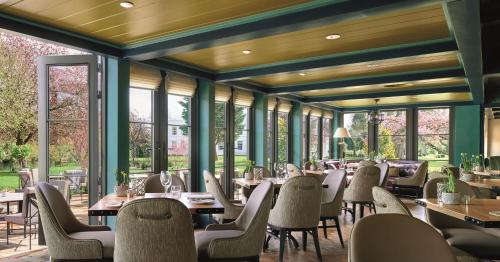 a restaurant with tables and chairs and windows at Monkey Island Estate - Small Luxury Hotels of the World in Bray
