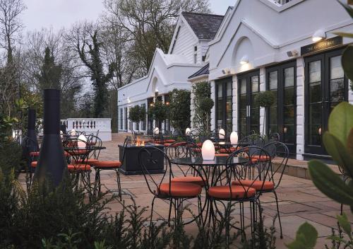 a group of tables and chairs in front of a building at Monkey Island Estate - Small Luxury Hotels of the World in Bray