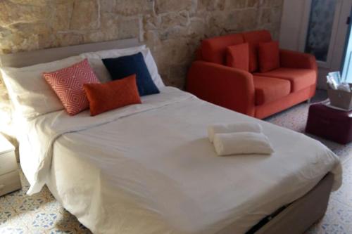 een slaapkamer met een bed en een rode stoel bij Zekka Studio in Valletta