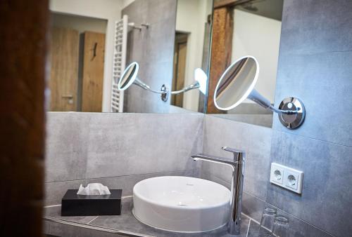 a bathroom with a sink and two mirrors on the wall at Hotel Reiler Hof in Reil