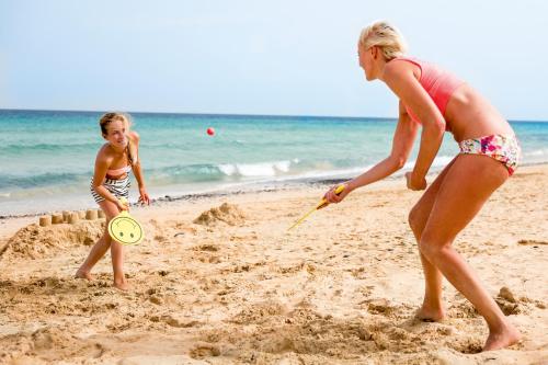 two girls playing with a frisbee on the beach at Aldiana Club Fuerteventura in Morro del Jable