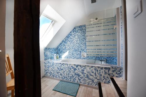 La salle de bains est pourvue d'une baignoire avec du carrelage bleu. dans l'établissement Hyper Centre - Cosy Appartement avec Cachet, à Rodez