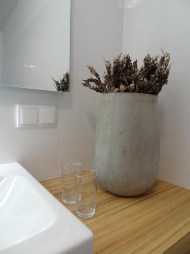 a vase with a plant in it on a table with two glasses at Nassfeld Apartments - "Traditionell anders" in Sonnenalpe Nassfeld