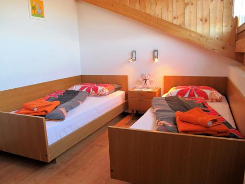 Duas camas num quarto com pisos em madeira em Rosenheim em Maranza