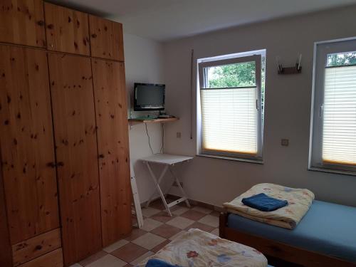 a bedroom with a bed and a tv and a window at Gästezimmer auf dem Campingplatz Konz in Konz
