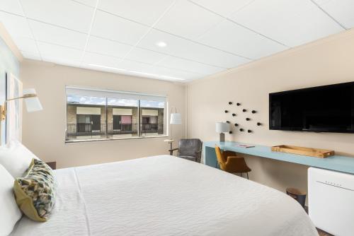 a bedroom with a bed and a desk and a tv at Riverwalk Plaza Hotel in San Antonio