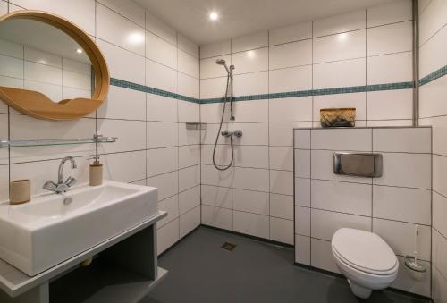 a bathroom with a sink and a toilet and a mirror at Rufus aan het water in Broek