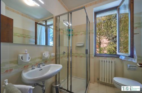 een badkamer met een wastafel en een glazen douche bij Casa Iris in Perledo