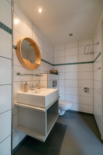 a bathroom with a sink and a toilet at Rufus aan het water in Broek