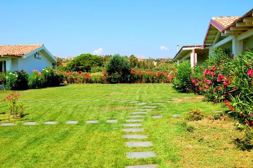 a garden with a path in the grass at Hotel Budoni Beach in Budoni