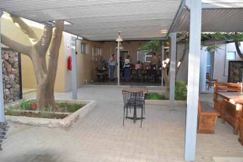 a patio with a table and chairs and a tree at Quiver Inn Guesthouse in Keetmanshoop