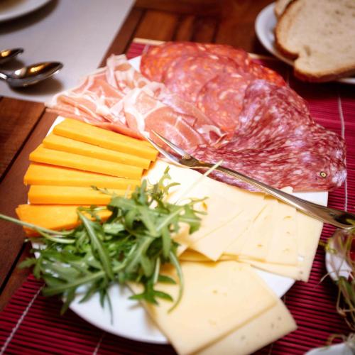 a plate of cheese and meats on a table at The 3Cities Auberge in Cospicua