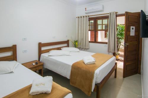 Habitación de hotel con 2 camas y ventana en Pousada Refugio de Paraty, en Paraty
