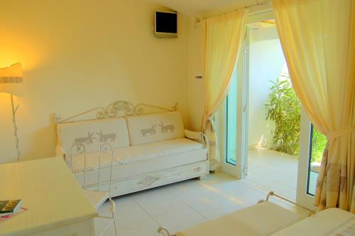 a room with a bed and a sliding glass door at Hotel Budoni Beach in Budoni