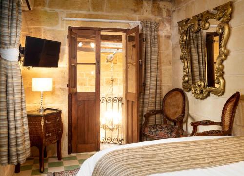 a bedroom with a bed and a mirror and a tv at The 3Cities Auberge in Cospicua