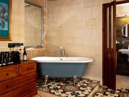 a bathroom with a tub and a sink at The 3Cities Auberge in Cospicua