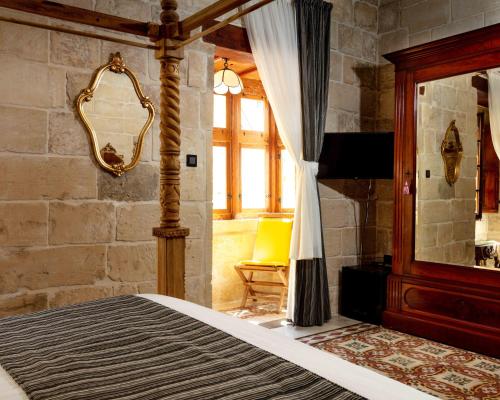a bedroom with a bed and a mirror at The 3Cities Auberge in Cospicua