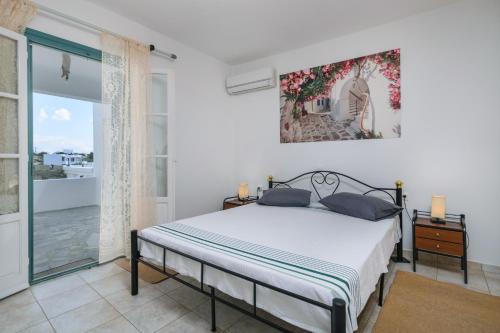 a bedroom with a bed and a large window at Zanart Maisonette in Tripití