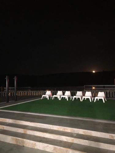 a group of chairs sitting on the grass at night at Albergue Mirador de Pedrouzo in O Pedrouzo