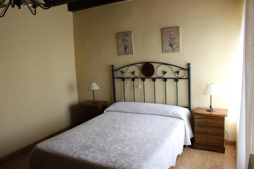 a bedroom with a bed and two night stands and two lamps at La Cuarta in Herrera de Pisuerga