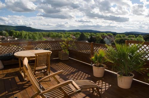 a patio with a table and chairs on a balcony at Gite DURANCE in Mallemort