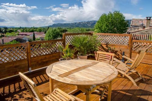 a wooden table and chairs on a deck at Gite DURANCE in Mallemort