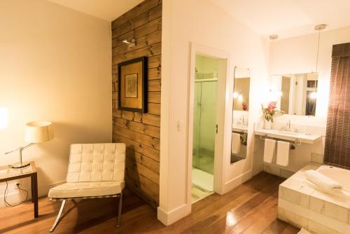 a bathroom with a bench and a chair and a sink at Altenhaus Pousada Itaipava in Itaipava