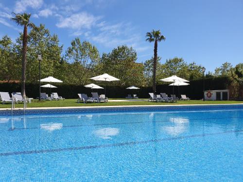a large swimming pool with chairs and umbrellas at Marina Tossa in Tossa de Mar
