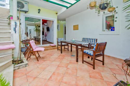 a patio with a table and chairs on a tile floor at Apartments Bubalo in Hvar