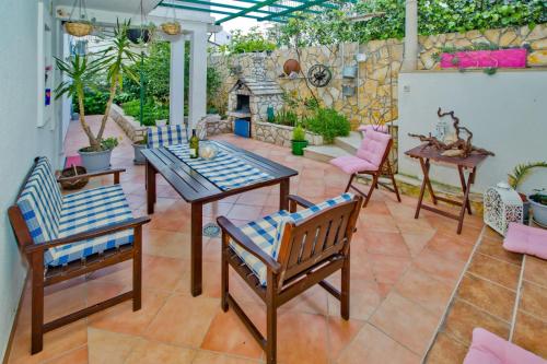 a patio with a table and chairs and a fireplace at Apartments Bubalo in Hvar