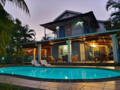 a villa with a swimming pool in front of a house at VILLA DES ILES MONT CHOISY in Mont Choisy