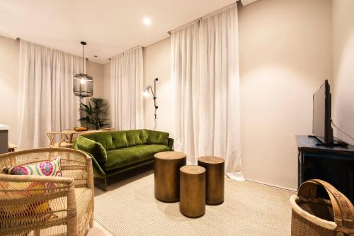a living room with a green couch and stools at U-Sense Granada Catedral in Granada