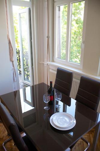 a dining room table with a plate and wine glasses at Five Season's Apartment in Budapest