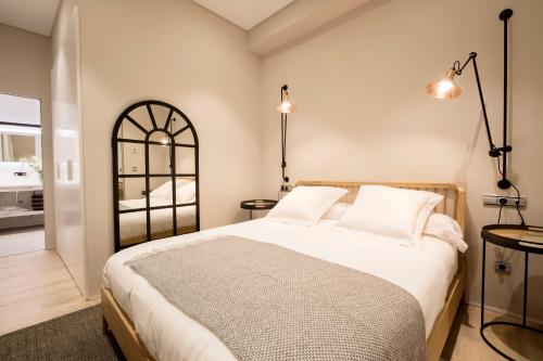 - une chambre avec un grand lit et deux lampes dans l'établissement U-Sense Granada Catedral, à Grenade