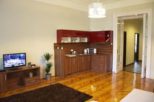 a living room with a kitchen with wooden floors at Five Season's Apartment in Budapest