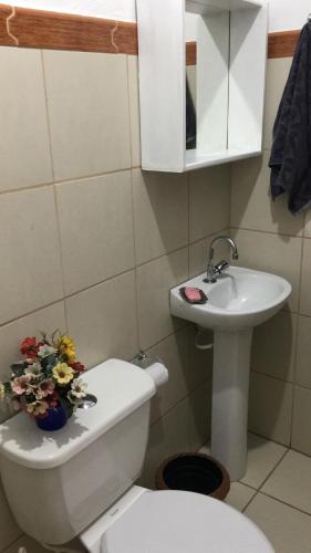 a small bathroom with a toilet and a sink at Casa quadra praia Jacaraipe! in Jacaraípe