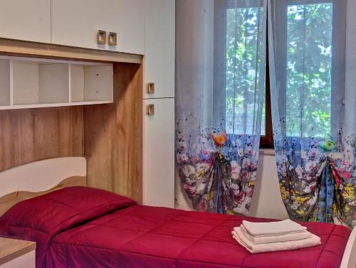 una camera con letto rosso e finestra di Villa Magnolia a Bolsena