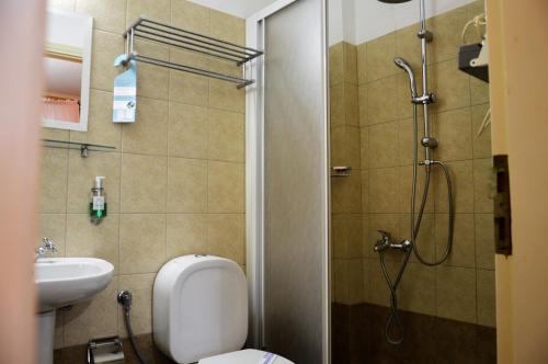 y baño con ducha, aseo y lavamanos. en Ilion Hotel, en Nafpaktos