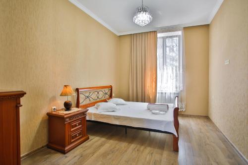 a bedroom with a bed and a table and a window at Apartment Anano in Kutaisi