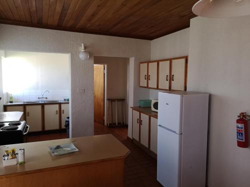 a kitchen with a white refrigerator and wooden cabinets at Kloofsig Holiday Cottages in Graskop