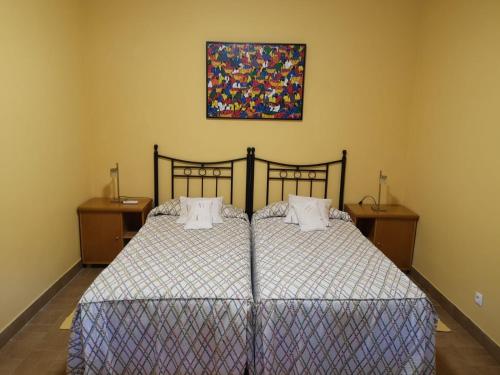 una camera da letto con un letto e un dipinto sul muro di Quinta Da Ponte a Barca dʼAlva