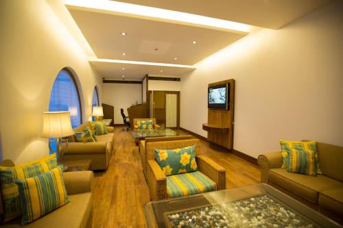 a large living room with couches and a tv at E Square The Fern, Pune in Pune
