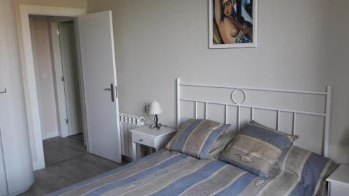 a bedroom with a bed with blue blankets and pillows at Mirador del Cantábrico in Lastres