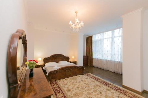 - une chambre avec un lit et un lustre dans l'établissement Diplomat Apartment on Sarayshyq st 34, à Astana