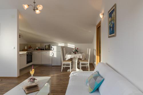 ein Wohnzimmer mit einem weißen Sofa und einem Tisch in der Unterkunft Apartments Bozica in Dubrovnik