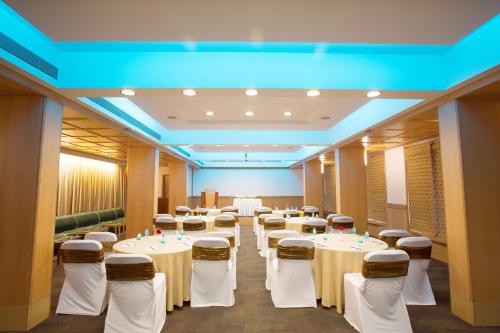 a conference room with white tables and chairs at E Square The Fern, Pune in Pune