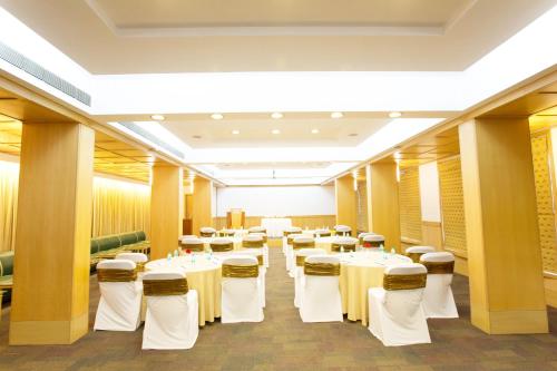 a conference room with white tables and chairs at E Square The Fern, Pune in Pune