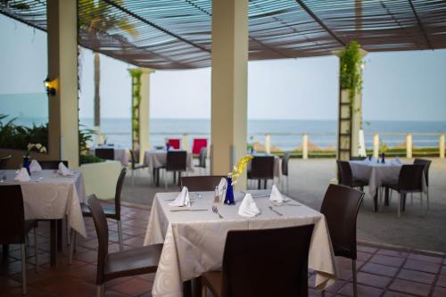a restaurant with tables and chairs with the ocean in the background at Samba Vallarta All Inclusive in Nuevo Vallarta 